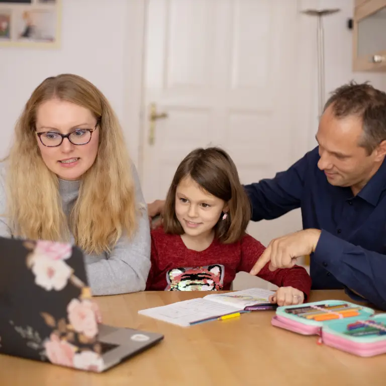 Parents helping their child with schoolwork at home before starting secondary school.