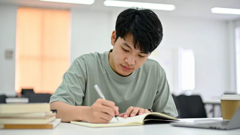 Student revising GCSE English with notes and textbooks before the exams.