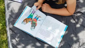 Child reading a book during the summer holidays to prepare for the 11+ exam