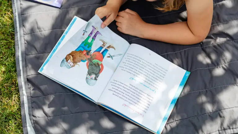 Child reading a book during the summer holidays to prepare for the 11+ exam