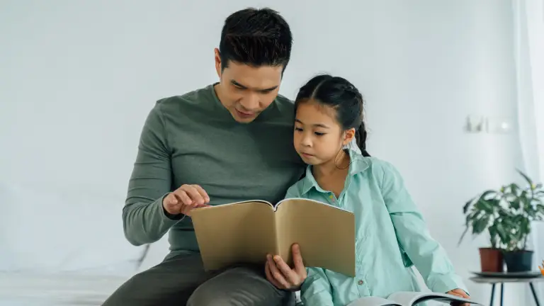 Parent helping their child prepare for the 11+ exam during the summer holidays.