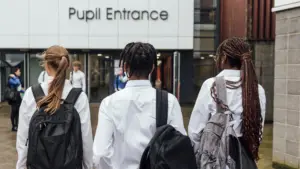 Student arriving at school with a backpack at the start of the new school year.