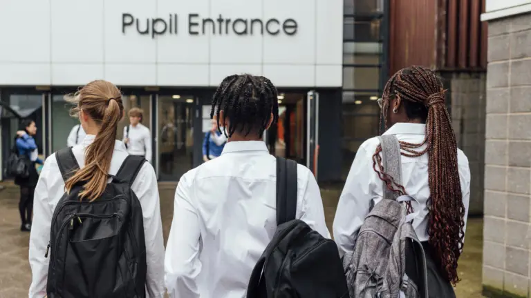 Student arriving at school with a backpack at the start of the new school year.
