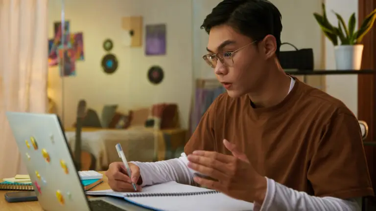 Secondary school student taking part in an online tutoring lesson using a laptop.